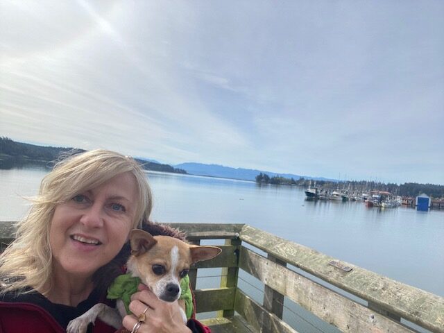 Doreen and her dog on a dock overlooking the ocean